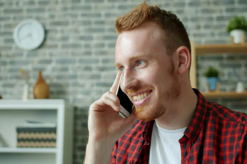 A tradesman smiling while taking a phone call
